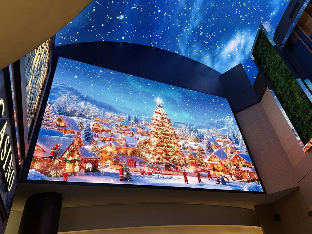 Large indoor digital Christmas display showing a snowy winter village in Korea