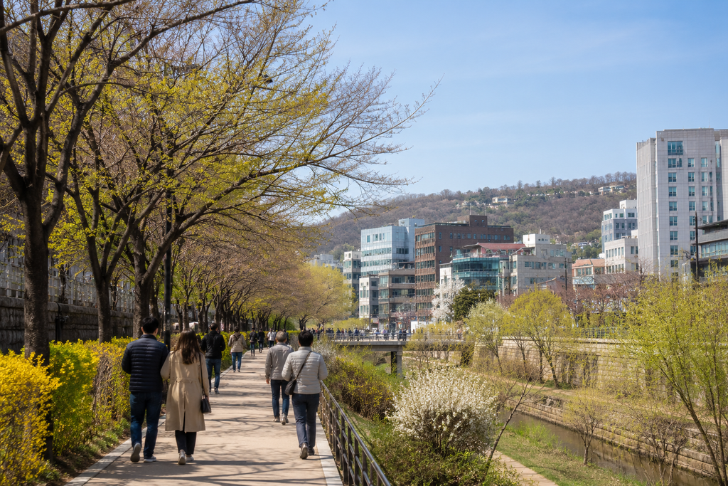 Early spring in Seoul with people walking among budding trees and spring flowers