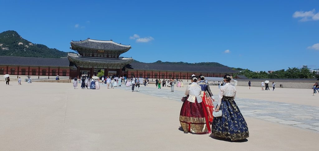 Visitors wearing colorful hanbok walking through Gyeongbokgung Palace in Seoul