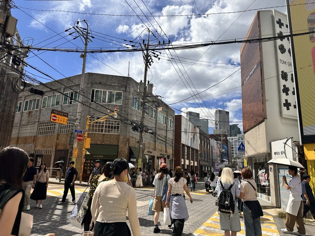 Crowded street mixing old buildings and new shops in Seongsu, Seoul