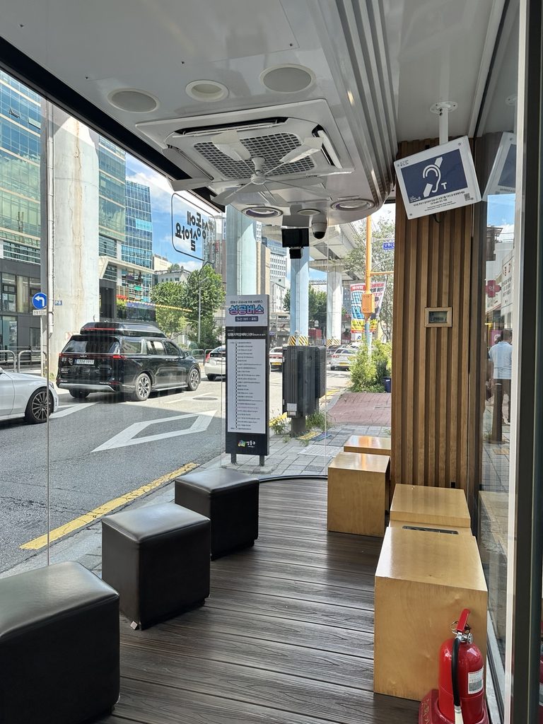 Inside a Seoul Smart Shelter with seating at a bus stop