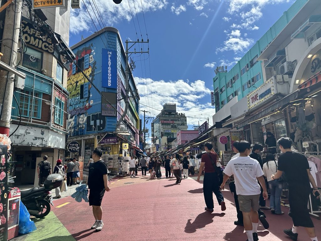 Busy shopping street in Hongdae filled with fashion stores and pedestrians