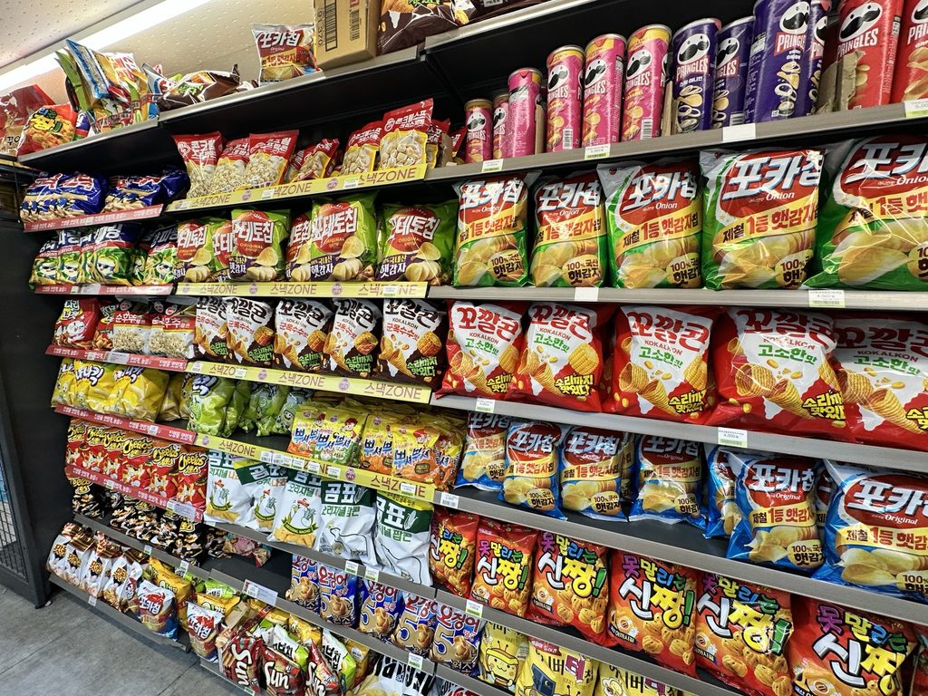 Shelves filled with popular Korean snacks, chips, and Pringles at a convenience store in Banpo Hangang Park, Seoul.